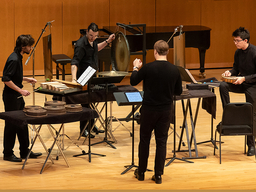 A group of musicians performs on percussion instruments.