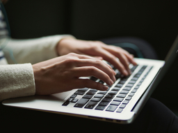 hands typing on a laptop computer