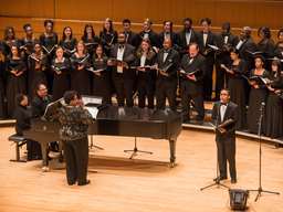 A chorus performs on a concert stage.