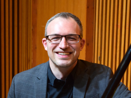 A headshot of a person wearing glasses.