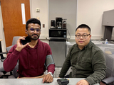 Dong Li (right) and graduate student Riishav Guptaa demonstrate how smart phone blood pressure monitoring may work.