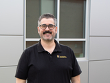 human in a black short sleeve shirt standing in front of a building